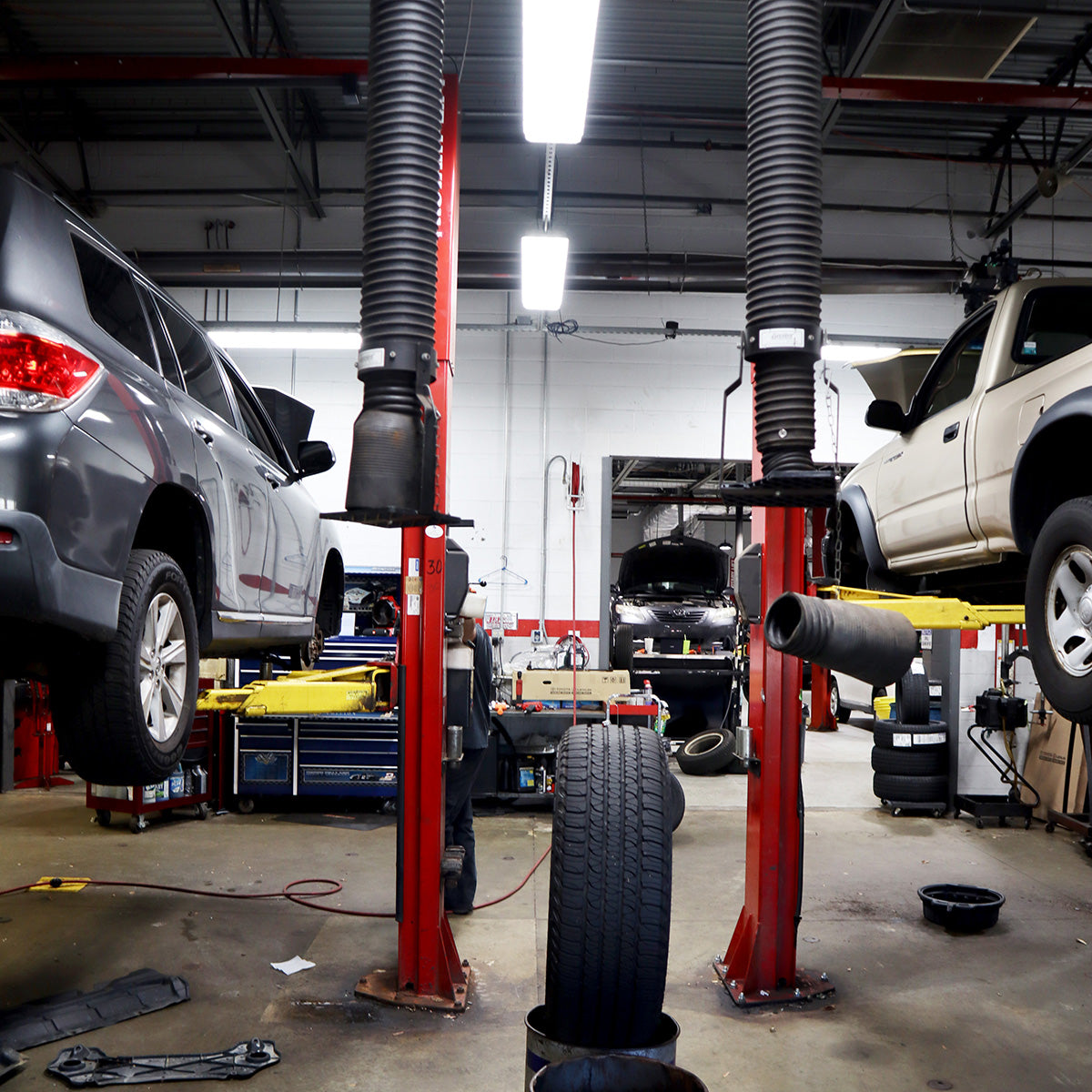 4ft High Bay LED Vapor Tight NSF 3-CCT light fixtures illuminating an industrial auto repair workshop space