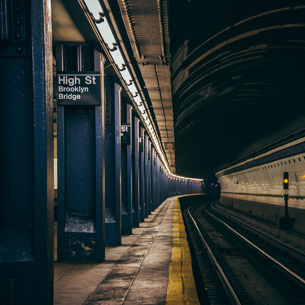 Empty subway platform illuminated by linear lights similar to a 4ft Emergency LED Tube 14W Type B design