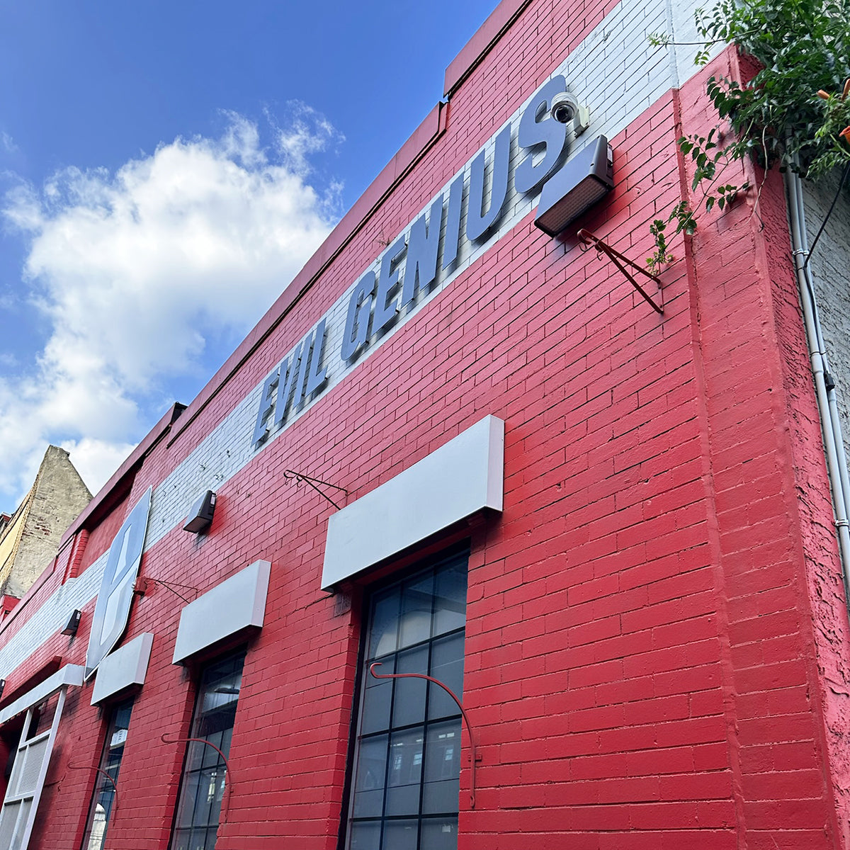Full Cutoff LED Wall Pack mounted on red brick commercial building illuminating doorways under blue sky