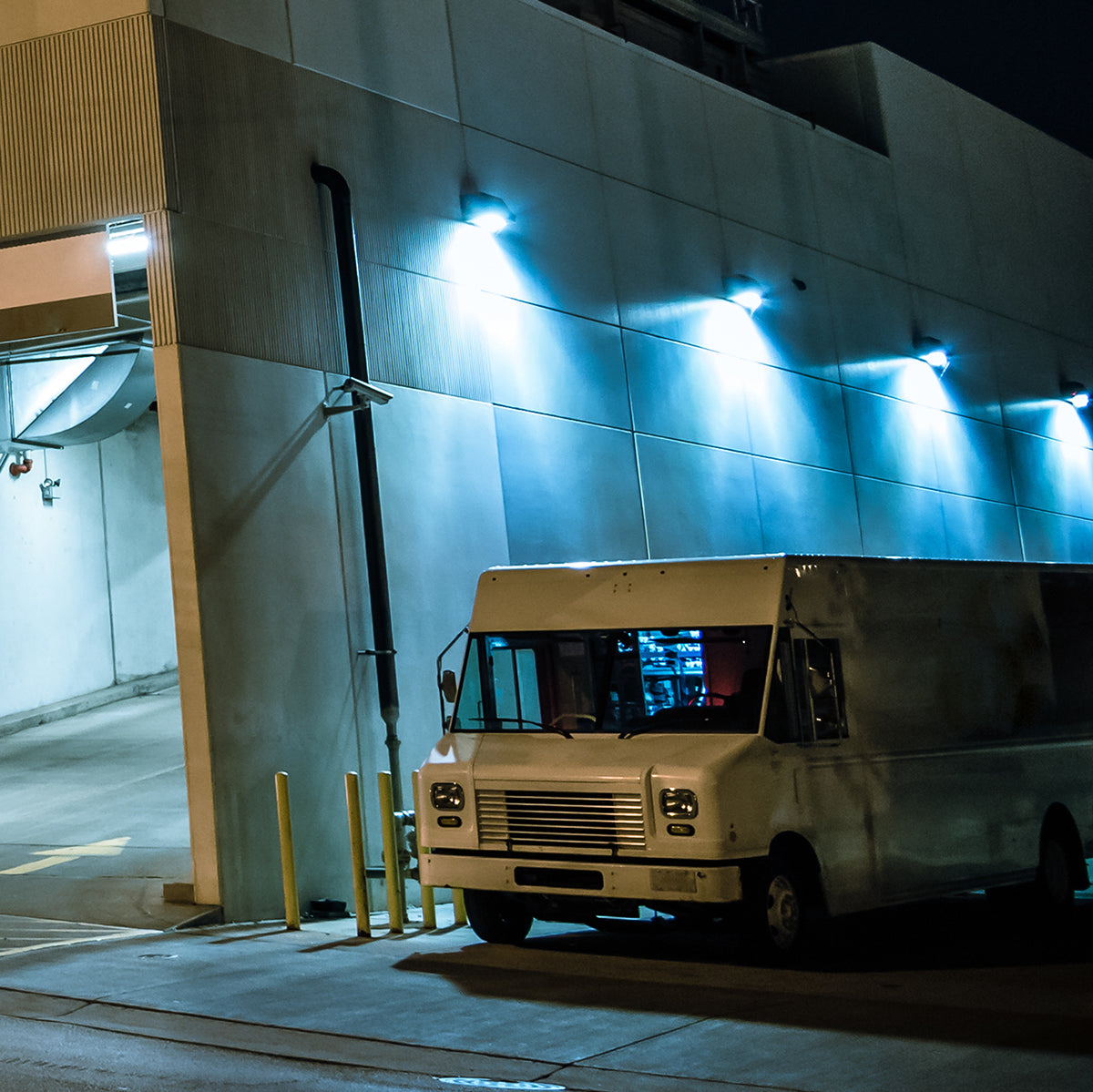 Semi Cutoff LED Wall Pack w Photocell lighting a building exterior and delivery truck at night