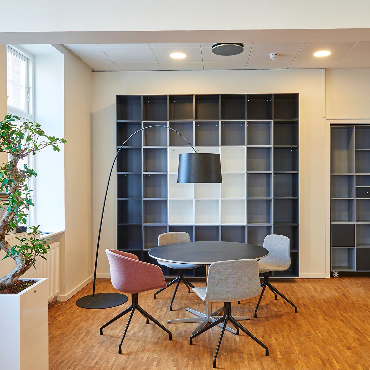 Modern office meeting area lit by 12" surface mount LED downlights with adjustable white light color temperature