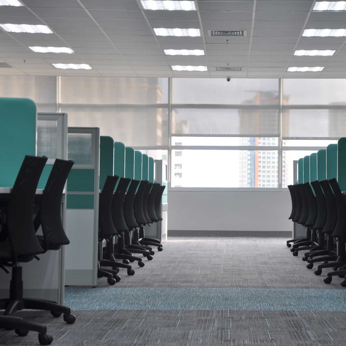 Modern office interior lit by 2x2 LED Troffer 3 CCT 18/25/30W RAB SWISH34 lights with workstations and chairs