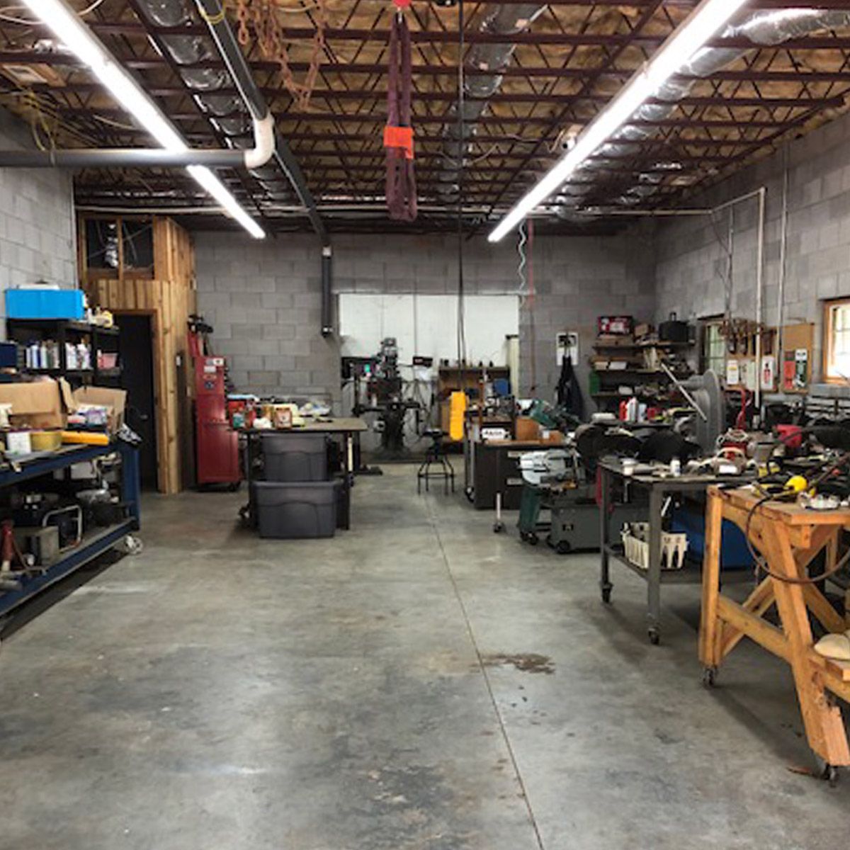 Interior of a workshop lit by multiple 4ft LED Tube 17W Type B fixtures for bright, efficient lighting.