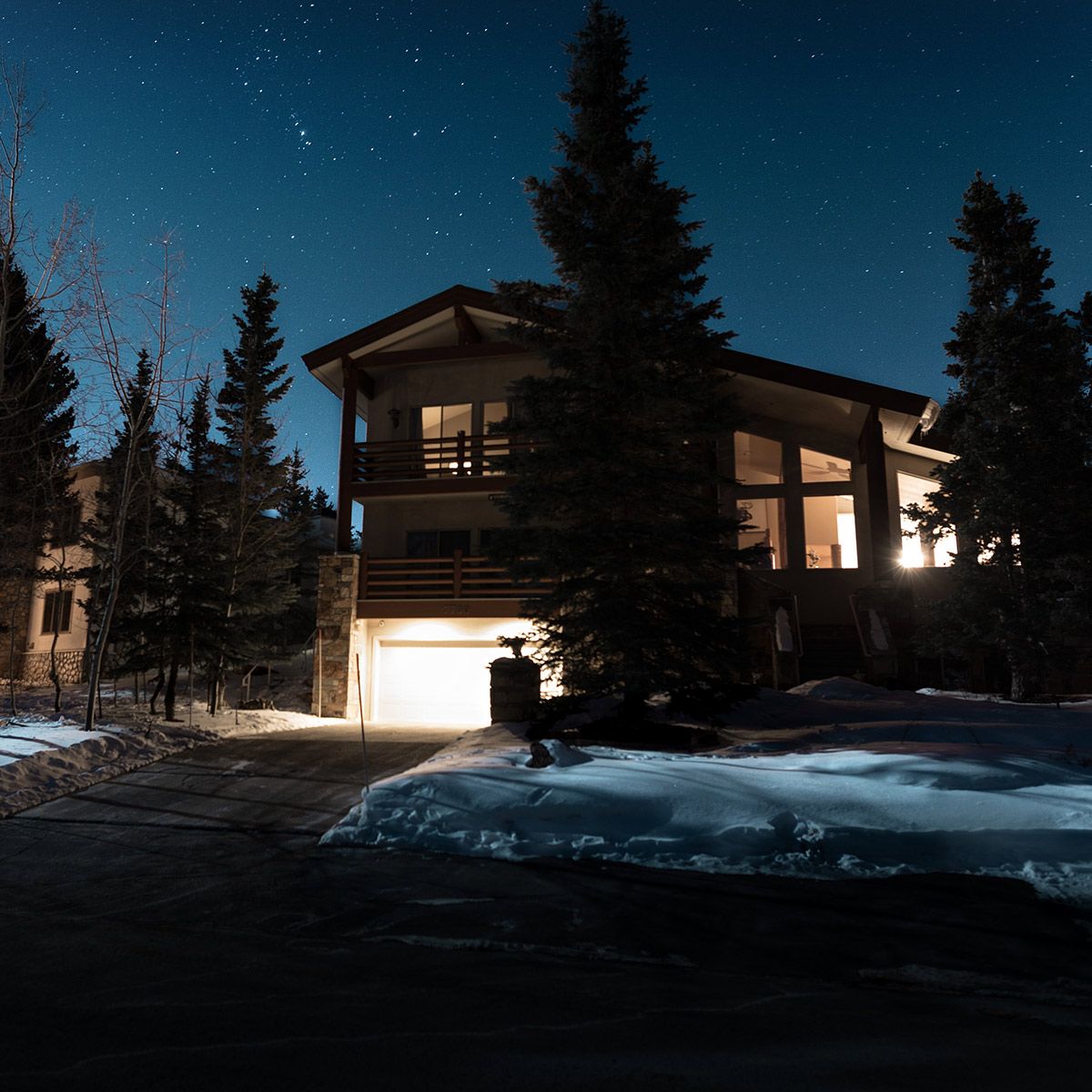 Mini LED Flood Light 3 CCT illuminating a snowy driveway and modern house exterior at night
