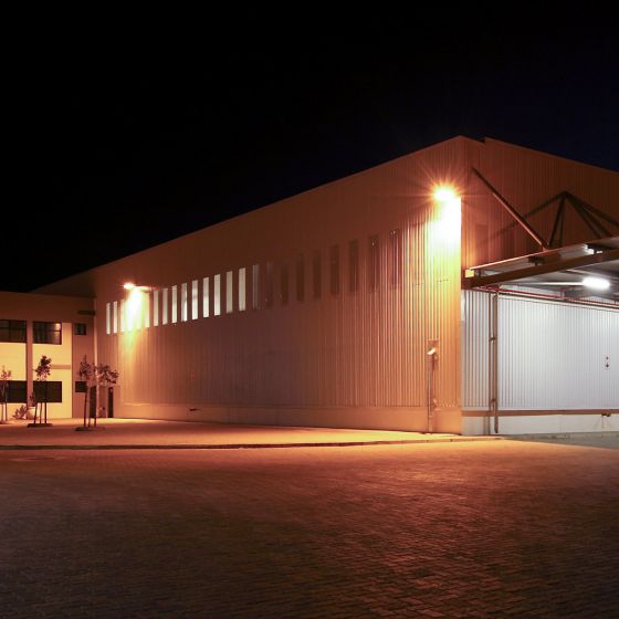 150W LED Flood Light illuminating exterior walls and parking area of a commercial building at night