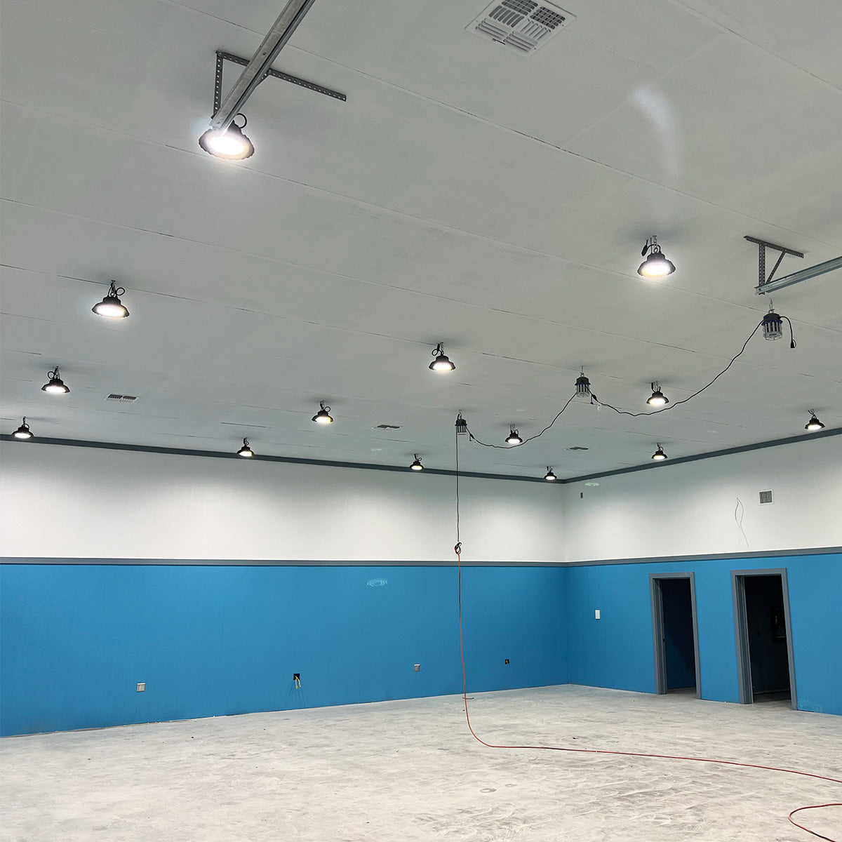 Spacious room illuminated by multiple UFO LED Low Bay 2 CCT 100W 80W 60W ceiling lights with bright white light