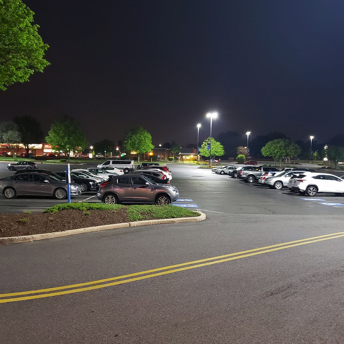 Parking lot illuminated at night by bright LED Shoebox Area Light - 600W fixtures for clear visibility and safety