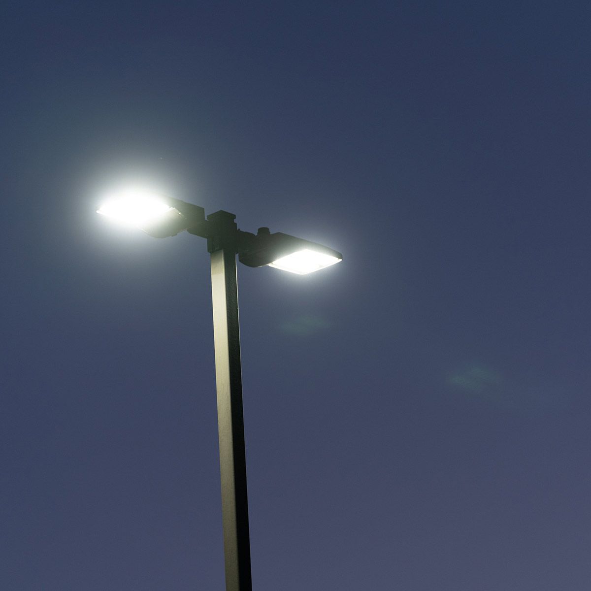 Brightline Shoebox Area Light 320W with bright white LED illumination on a pole against dusk sky