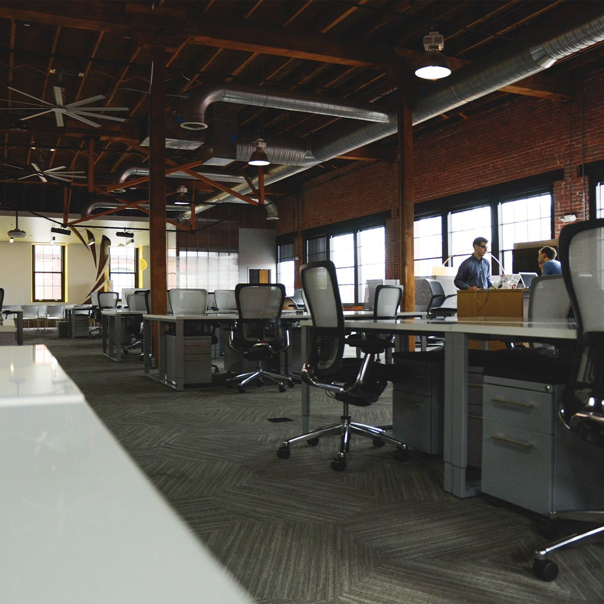 Modern office interior with Germicidal UVC Disinfecting Linear Light fixtures mounted on ceiling beams.