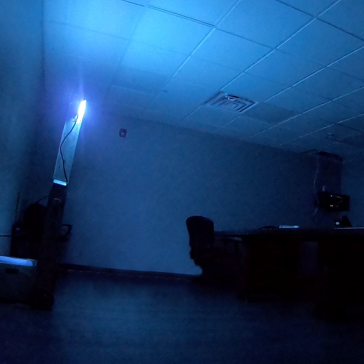 Germicidal UVC Disinfecting Linear Light operating in dark room for surface sanitizing and safety testing.