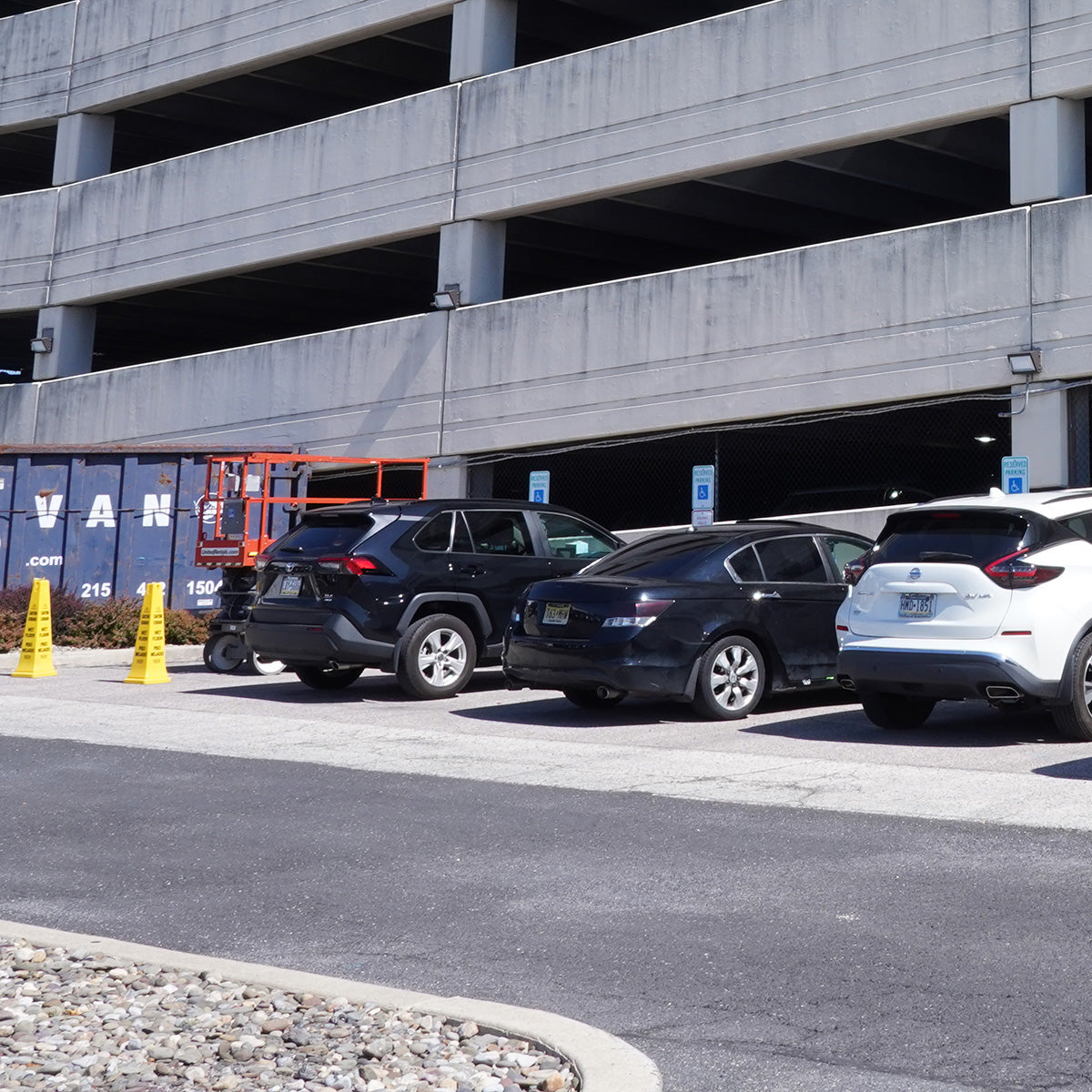 80W MaxLite Open Face LED Wall Pack installed on a commercial parking garage exterior wall above parked cars