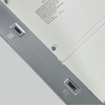 Close-up of a LED light fixture with dip switches for selecting CCT and wattage. 
