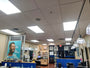 Interior view of a well-lit salon with product shelves, styling stations, and ceiling lights glowing warmly.