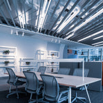 Modern office space illuminated by 4ft LED Tube 5 CCT Selectable 14W 18W 20W Type B lights overhead and on shelves