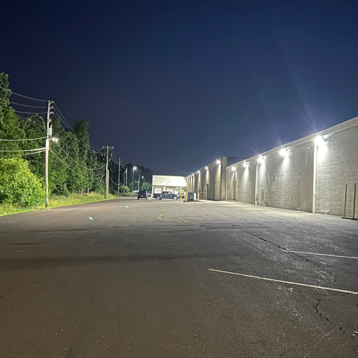 Wide outdoor area illuminated at night by powerful Selectable FL Series LED Flood Lights mounted on building wall