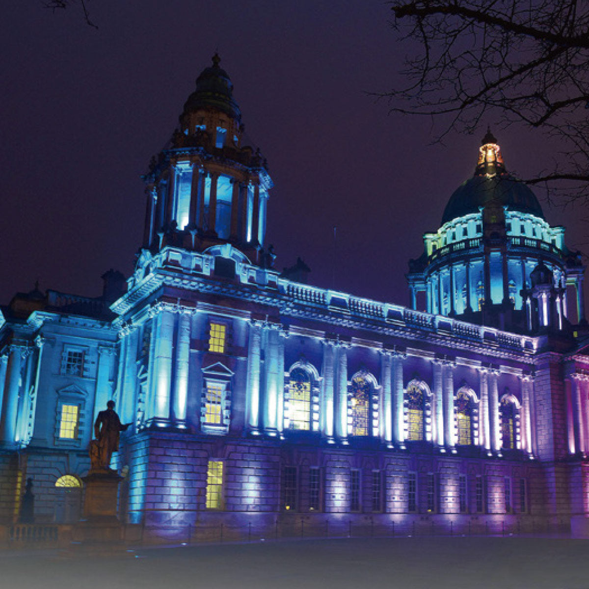 Historic building facade illuminated with vibrant blue and purple hues using RGBW LED linear wall washer light