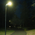 Solar LED Street & Area Light - 30W illuminating a dark park pathway with bright, efficient lighting at night