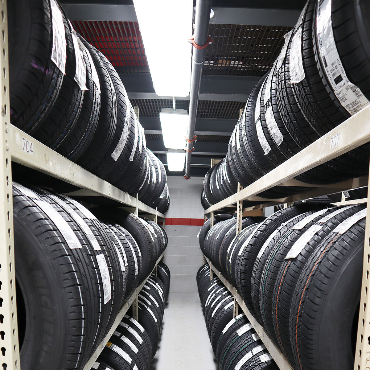 4ft High Bay LED Vapor Tight light fixture illuminating industrial storage room with stacked tires on racks