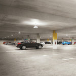 LED Canopy Light with Uplight - 3 CCT illuminating a spacious parking garage with clear, even lighting