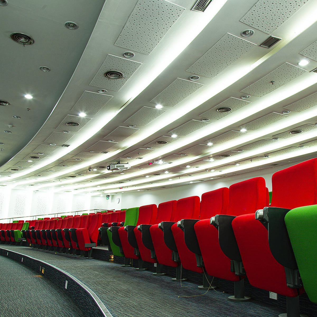 8" Architectural LED Downlight installed in curved ceiling of auditorium with red and green seats