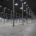Bright industrial warehouse lit by UFO LED High Bay 3 CCT 150/120/100W fixtures with high ceiling and metal beams