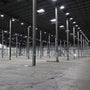 Bright industrial warehouse lit by UFO LED High Bay 3 CCT 150/120/100W fixtures with high ceiling and metal beams