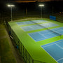 Value LED Flood Light illuminating multiple outdoor tennis courts with bright and even coverage during nighttime.