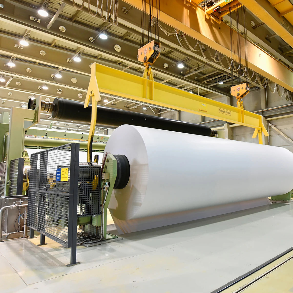 Industrial paper manufacturing facility with heavy machinery and bright overhead lighting for hazardous locations marine grade use