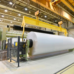 Industrial paper manufacturing facility with heavy machinery and bright overhead lighting for hazardous locations marine grade use