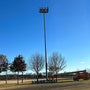 LED High Mast Light mounted on tall pole illuminating a large outdoor area under a clear blue sky