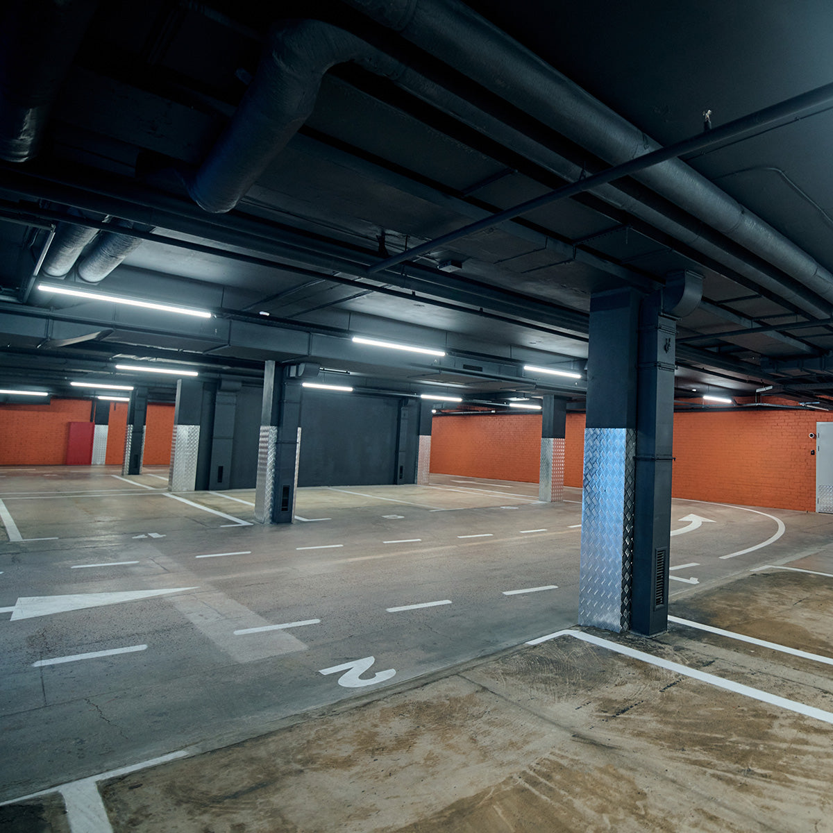4ft LED shop lights installed in a parking garage providing bright, energy-efficient illumination above parking spaces