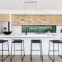 Modern kitchen with LED Wave Linear Pendant Light 3-CCT 35W above white island and black bar stools.
