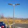 Solar LED Area Light with Tiltable Lens - 30W mounted on pole illuminating outdoor parking area under clear sky