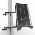 A wall-mounted solar sign light fixture with a black photovoltaic panel, silver metal frame, and black mounting brackets attached to a sign top, shown against a white background.