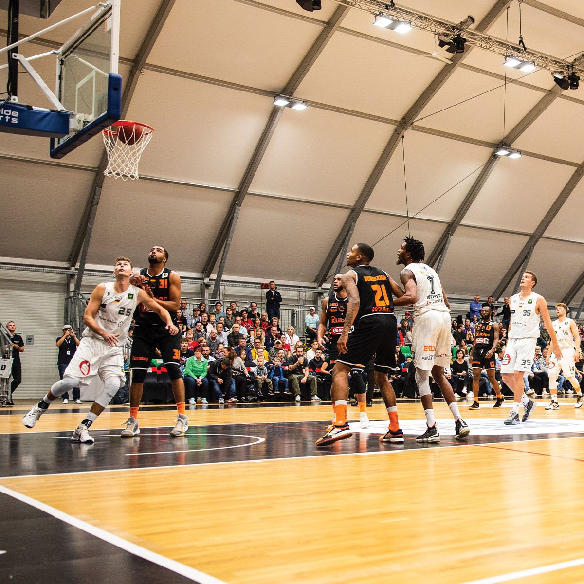 Indoor basketball court illuminated by Linear LED High Bay with swappable optics and durable IP66 IK10 design