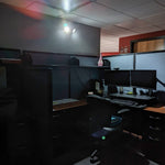 Dual Head LED Emergency Light - Remote Capable illuminating a dark office cubicle with two adjustable lamps during outage.