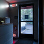 LED Exit Sign & Emergency Light Combo remote capable mounted above a dark office exit door with emergency lights on sides