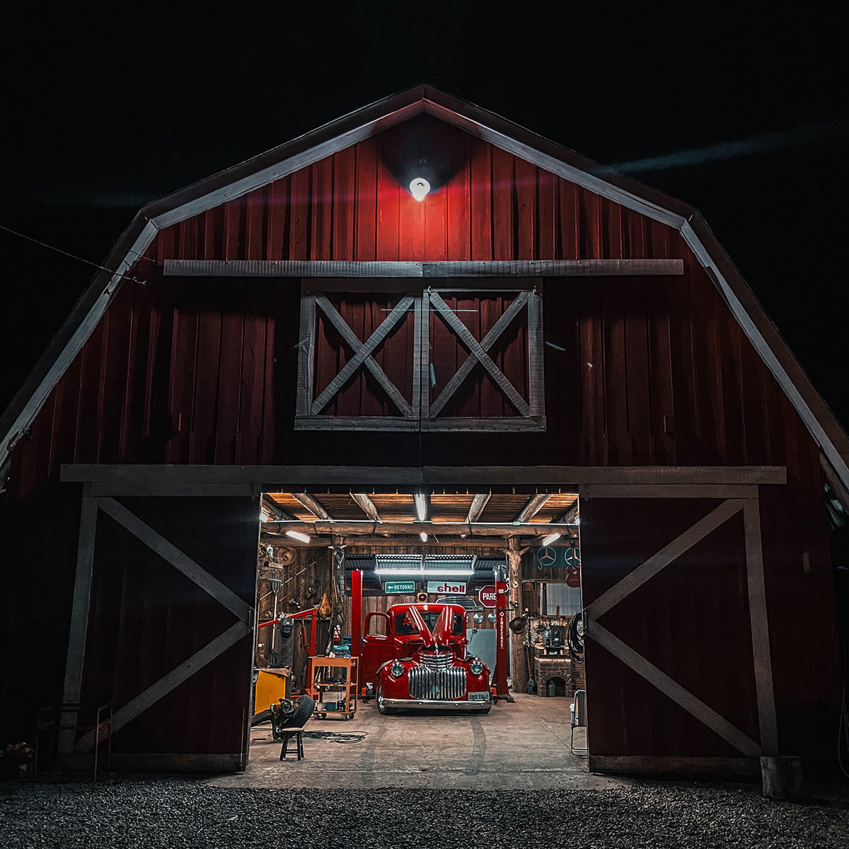 Red barn illuminated at night by LED Barn Light with Photocell - 27W mounted above the entrance.