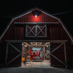 Red barn illuminated at night by LED Barn Light with Photocell - 27W mounted above the entrance.