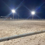 LED Flood Light - 135W outdoor lighting illuminating a large fenced area with bright white light at night
