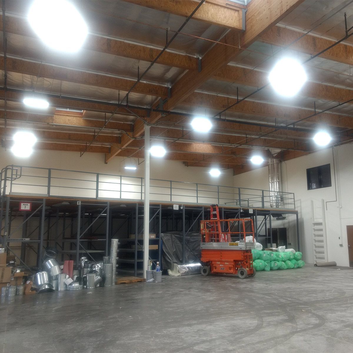 Industrial warehouse brightly lit with Linear LED High Bay 120W 17400 lm fixtures mounted on ceiling beams