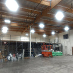 Industrial warehouse brightly lit with Linear LED High Bay 120W 17400 lm fixtures mounted on ceiling beams