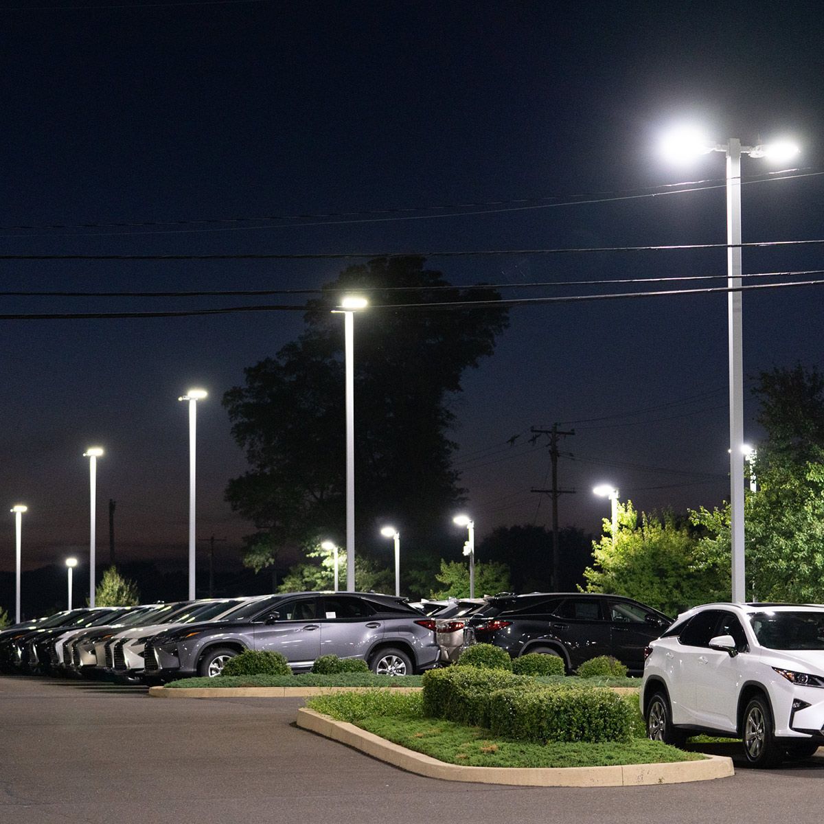 LED Shoebox Area Light 150W 21,000 lumens illuminating a parking lot at night with bright white light