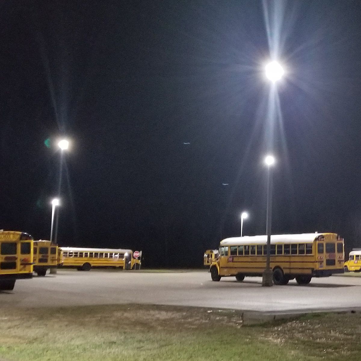 Parking lot illuminated by bright LED High Bay Retrofit Lamp E39 135W providing energy-efficient lighting with motion sensor.