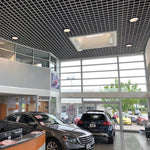 Modern commercial interior with LED High Bay Retrofit Lamp E39 150W illuminating a car showroom space
